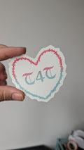 Sticker of text stating "T4T" with an illustrated barbed wire border in the shape of a love heart. The text and illustration on the sticker is in the colours pink and blue (the colours of the transgender pride flag).
