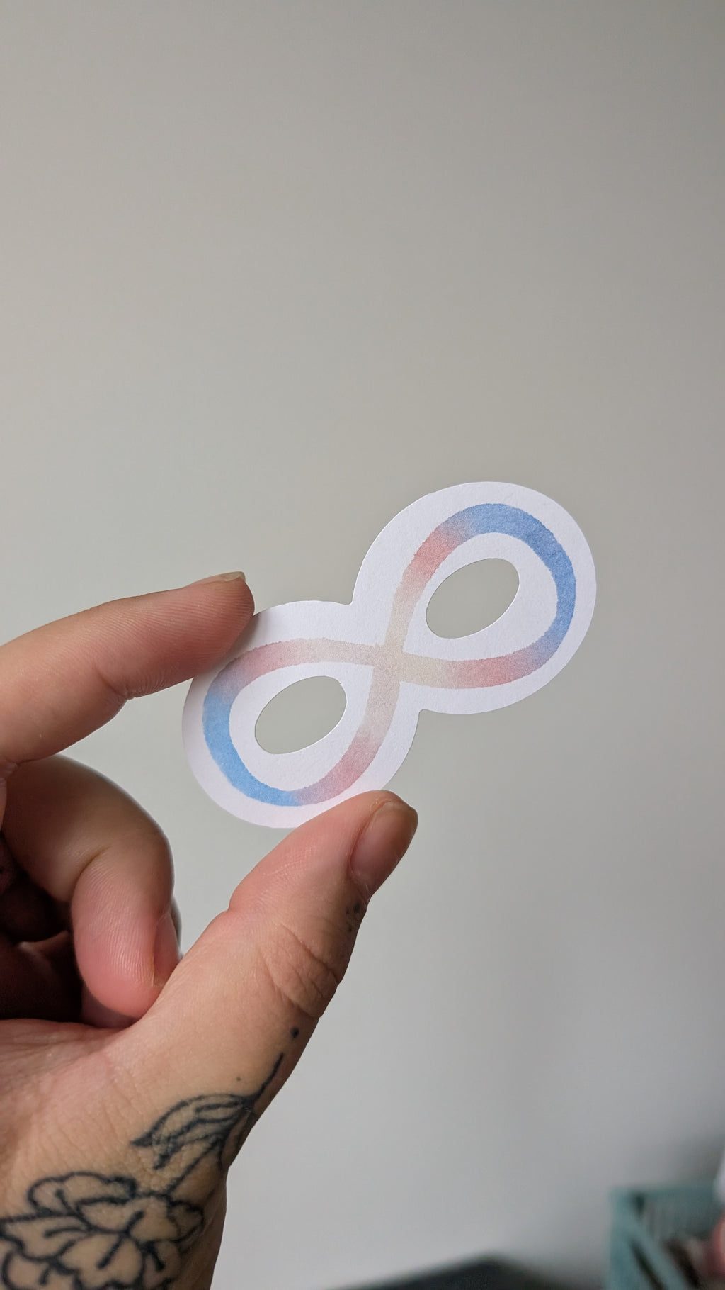 Sticker of an infinity symbol featuring the colours blue, white and pink (the colours of the transgender pride flag).